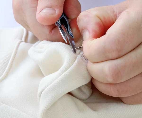 Hand finishing details on a sportswear garment